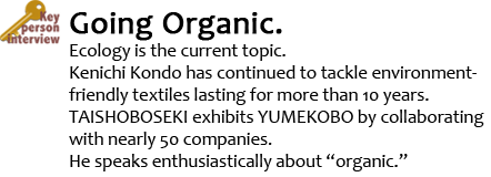 Key Person Interview Going Organic.  Ecology is the current topic. Kenichi Kondo has continued to tackle environment-friendly textiles lasting for more than 10 years. TAISHOBOSEKI exhibits YUMEKOBO by collaborating with nearly 50 companies.
